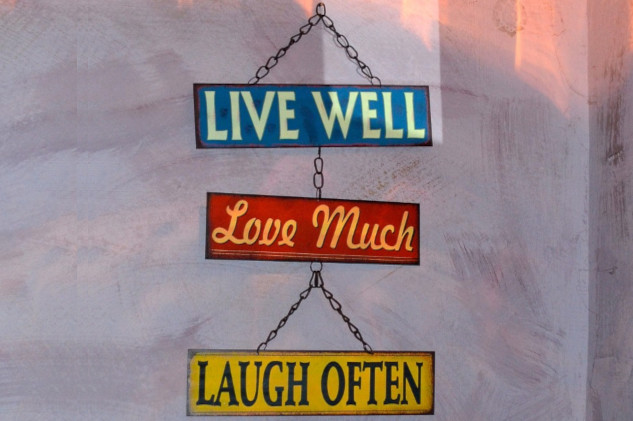 a sign that says: Live Well, Love Much, Laugh Often