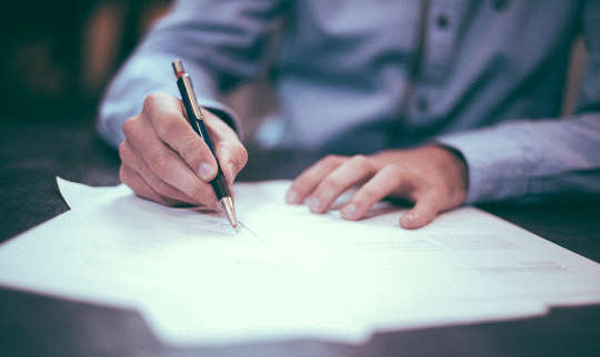 picture of a man writing on sheets of paper