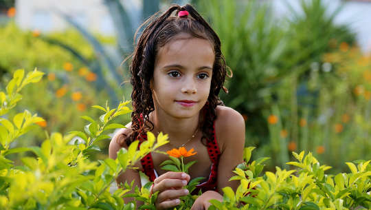 young girl in a field of plants and flowers