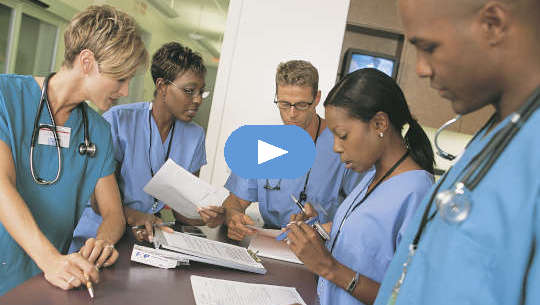 group of healthcare professionals standing around a desk or table