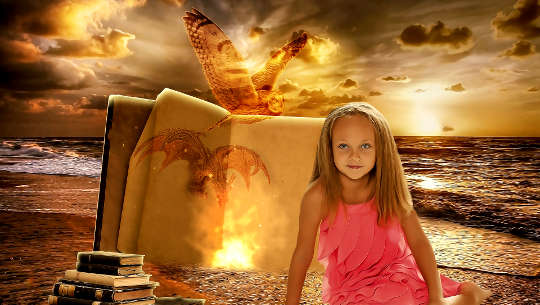 young girl sitting on the beach with s bright light and books