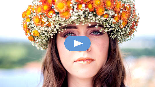 woman wearing a crown of flowers staring with an unwavering gaze