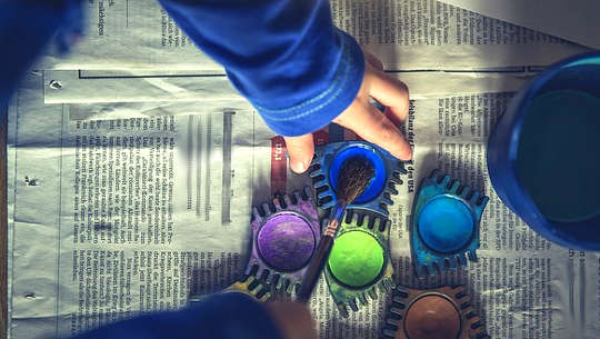 child's hand reaching for colors