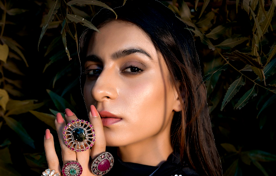 a woman wearing multiple gemstone rings on her fingers