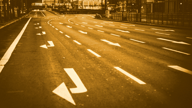 a road with many lanes going straight ahead, and one lane making a sharp right turn