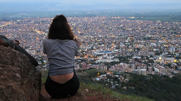 a woman sitting overlooking a city