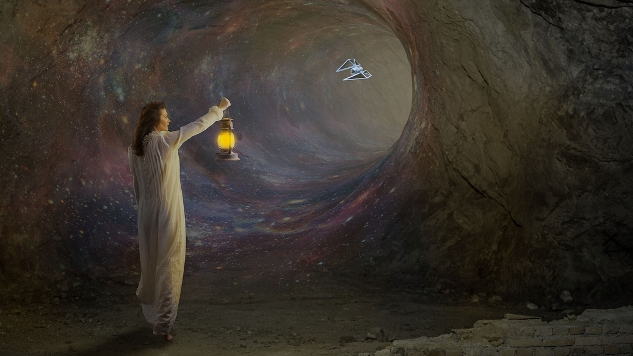 a young woman holding a lantern in a dark wormhole-like cave