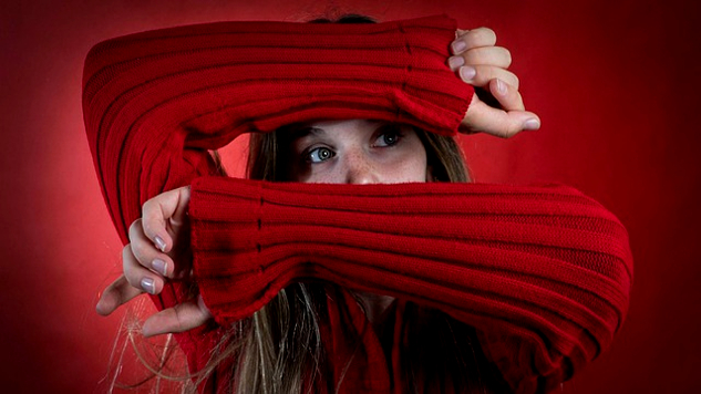 young woman with her arms over her face