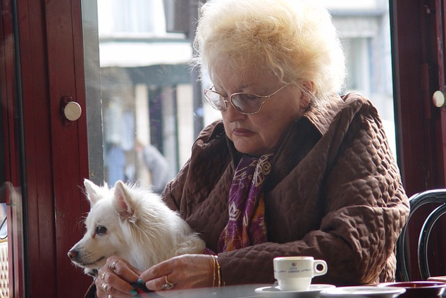 an old woman holding a dog on her lap