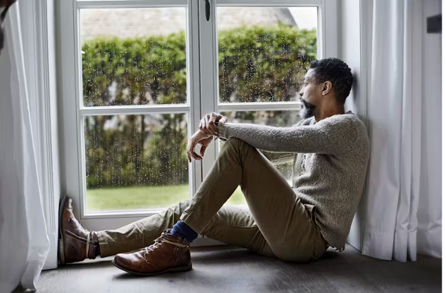 man sitting looking outside the window