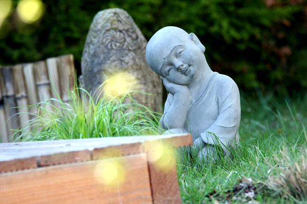 a small statue in a zen garden