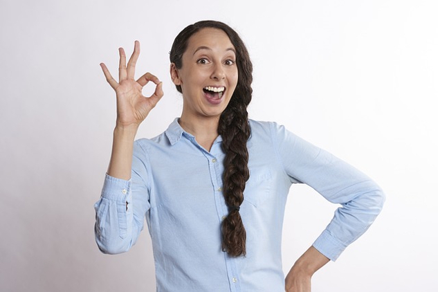 woman with a big smile and fingers in an "a-ok" symbol