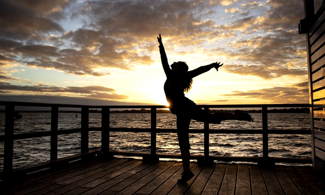 a woman dancing on a pier