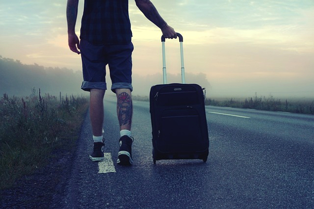 a traveler pullilng a carry-on bag with wheels