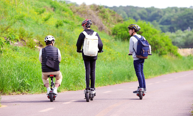 three siblings on the road wearing backpacks