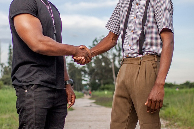 two men from different backgrounds shaking hands