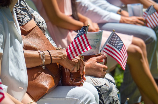 people sitting in a stadium holding small flags in their hands