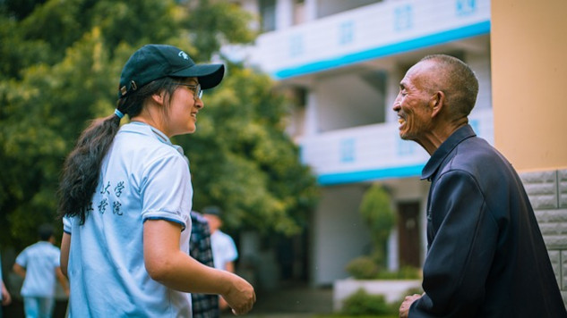 a young person speaking with an elderly man