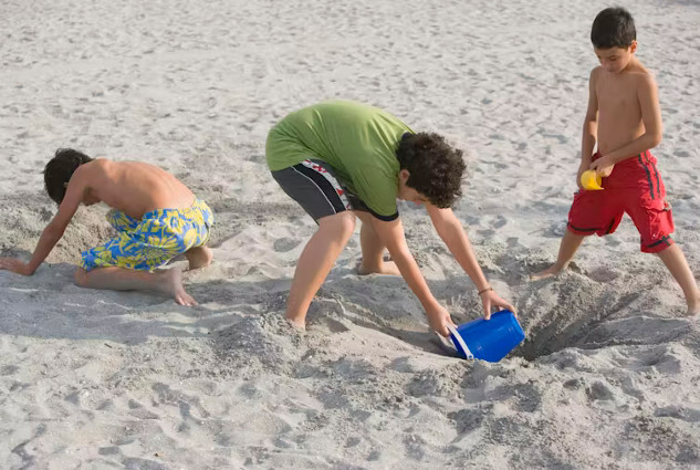 Children building sandcastles and tunnels this summer 