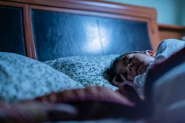 Child sleeping in bed with a soft toy, representing the importance of sleep for brain development and emotional health in children.