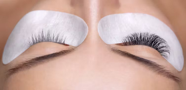 Close-up of a woman's eye with eyelash extensions, highlighting potential health 