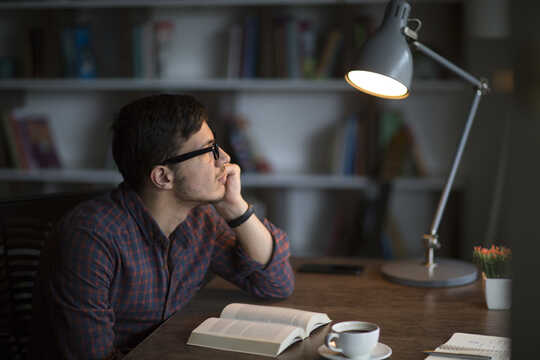 man with book looking off into distance