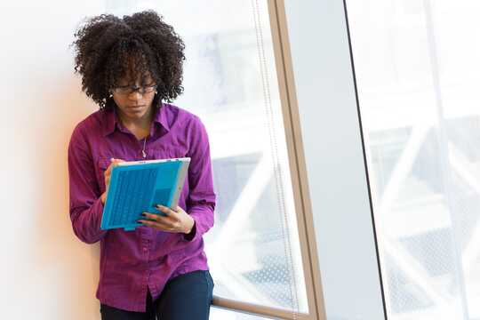 A woman in an office pores over a document.