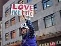 a young woman holding up a sign that reads: Love not Hate