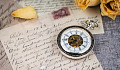 a pocket watch resting on a hand-written letter