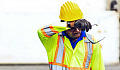 A construction worker wipes his forehead in the heat