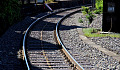 railroad tracks curving around the edge of a building to an unknown destination