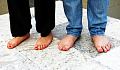 two pairs of bare feet standing firm