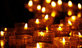 a group of lit votive candles