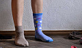 photo of a pair of legs wearing two very different color socks